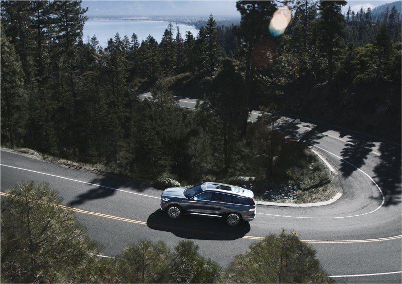 A 2023 Lincoln Aviator® SUV is being driven on a winding mountain road | Spitzer Lincoln DuBois in Du Bois PA