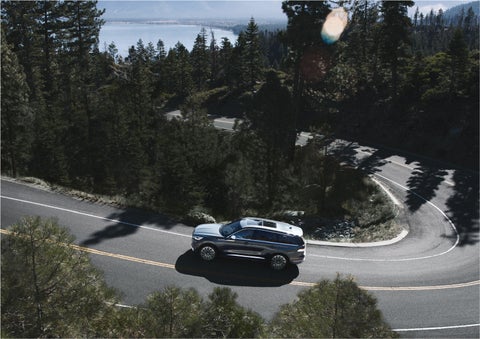 A 2023 Lincoln Aviator® SUV is being driven on a winding mountain road | Spitzer Lincoln DuBois in Du Bois PA