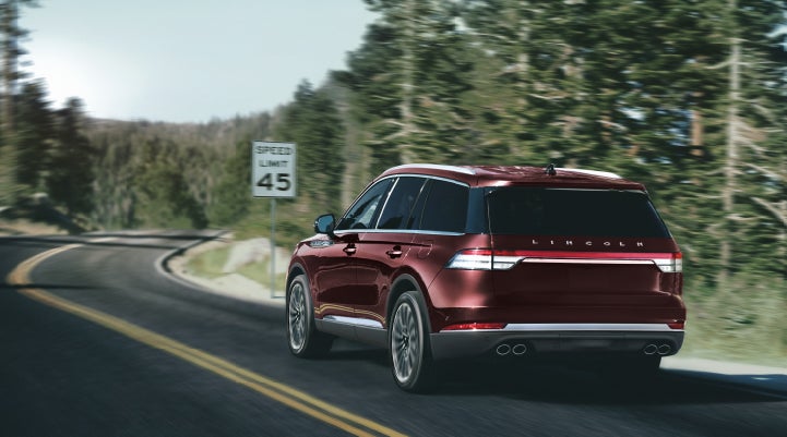 A 2024 Lincoln Aviator® SUV is being driven on a winding mountain road | Spitzer Lincoln DuBois in Du Bois PA
