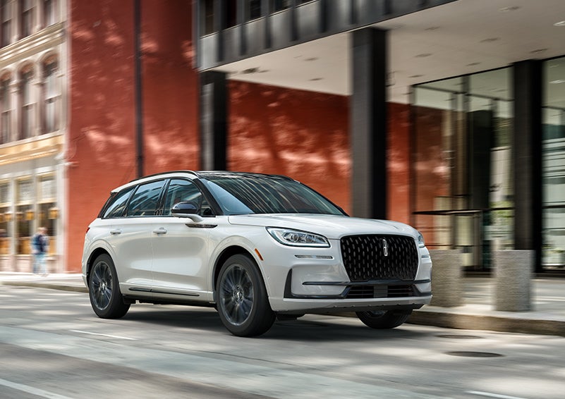 The 2024 Lincoln Corsair® SUV with the Jet Appearance Package and a Pristine White exterior is parked on a city street. | Spitzer Lincoln DuBois in Du Bois PA