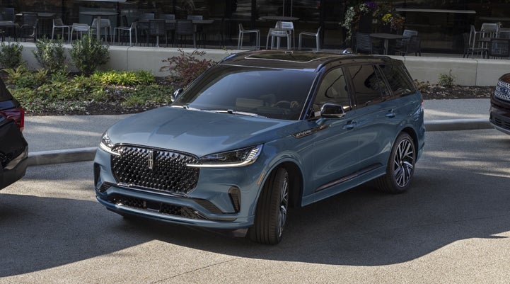 A Whisper Blue 2025 Lincoln Aviator® SUV is parked outside a modern building showcasing the driver’s side of the vehicle. | Spitzer Lincoln DuBois in Du Bois PA