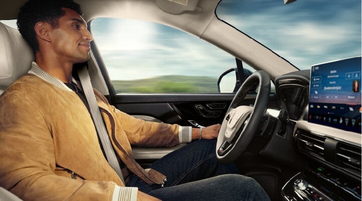 A person is shown using Lincoln BlueCruise hands-free highway driving technology on a divided highway called a Hands-Free Blue Zone. | Spitzer Lincoln DuBois in Du Bois PA
