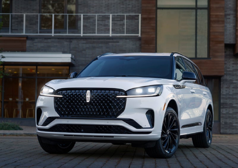 A 2026 Lincoln Aviator® Reserve model is shown with the available Jet Appearance Package parked near a restaurant. | Spitzer Lincoln DuBois in Du Bois PA