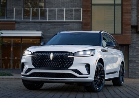 A 2026 Lincoln Aviator® Reserve model is shown with the available Jet Appearance Package parked near a restaurant. | Spitzer Lincoln DuBois in Du Bois PA