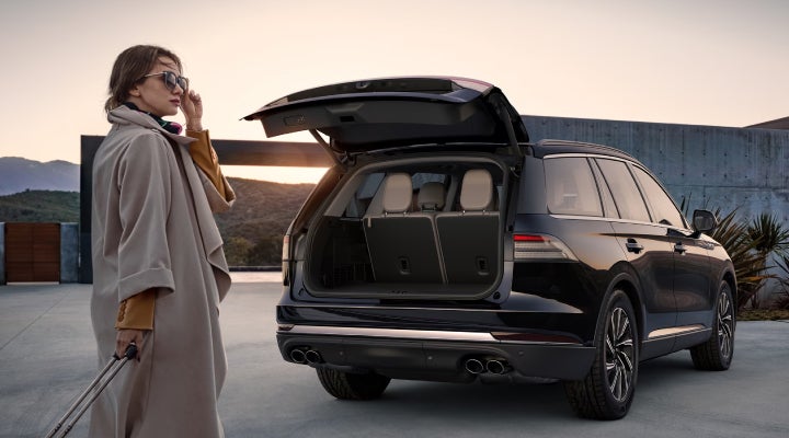 A woman approaches a 2026 Lincoln Aviator® SUV with its rear liftgate open. | Spitzer Lincoln DuBois in Du Bois PA
