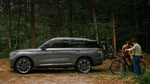 A father and son load e-bikes on a bike rack attached to a 2027 Lincoln Aviator® SUV. | Spitzer Lincoln DuBois in Du Bois PA