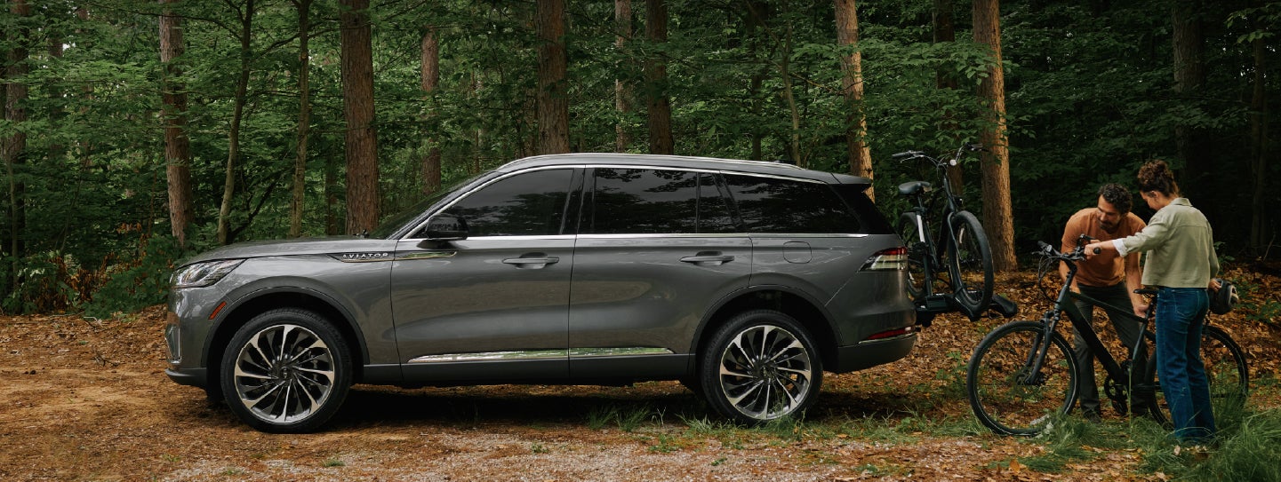 A father and son load e-bikes on a bike rack attached to a 2027 Lincoln Aviator® SUV. | Spitzer Lincoln DuBois in Du Bois PA